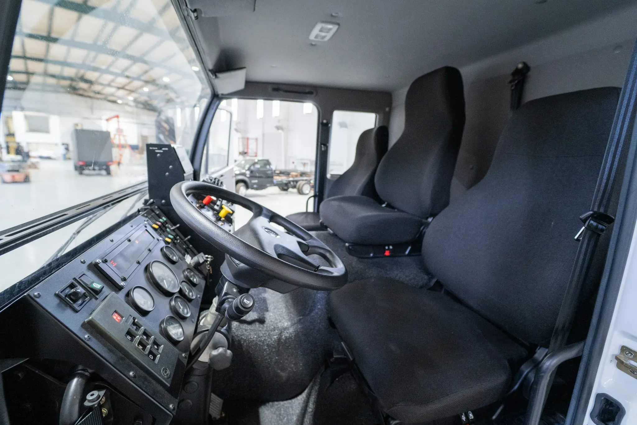 Inside the three-person cab of the Acela Monterra 6x6 — steering wheel, gauges, and seats