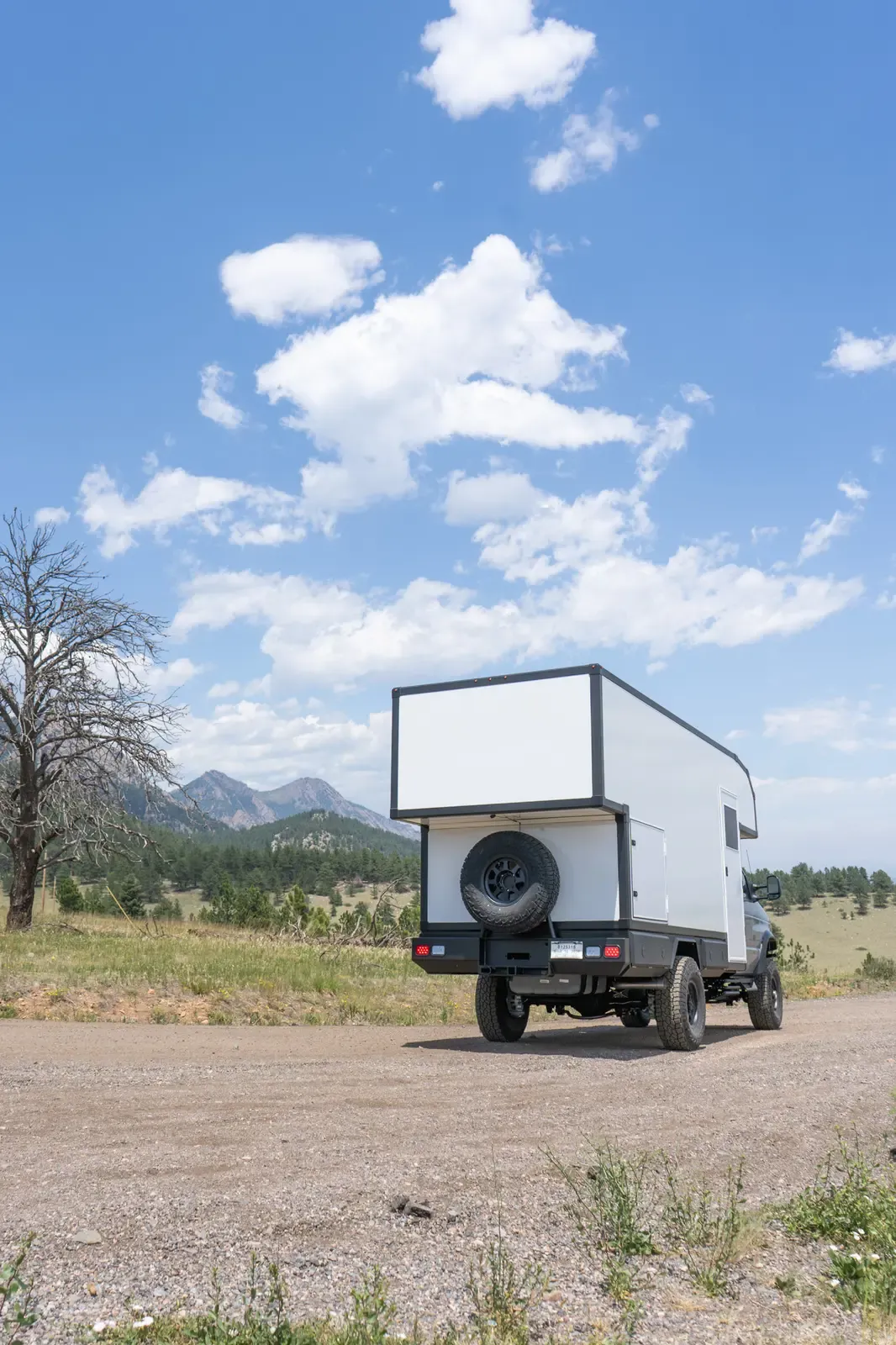 Silver-cab Ford E-450 expedition camper, rear view showing the composite cabover body