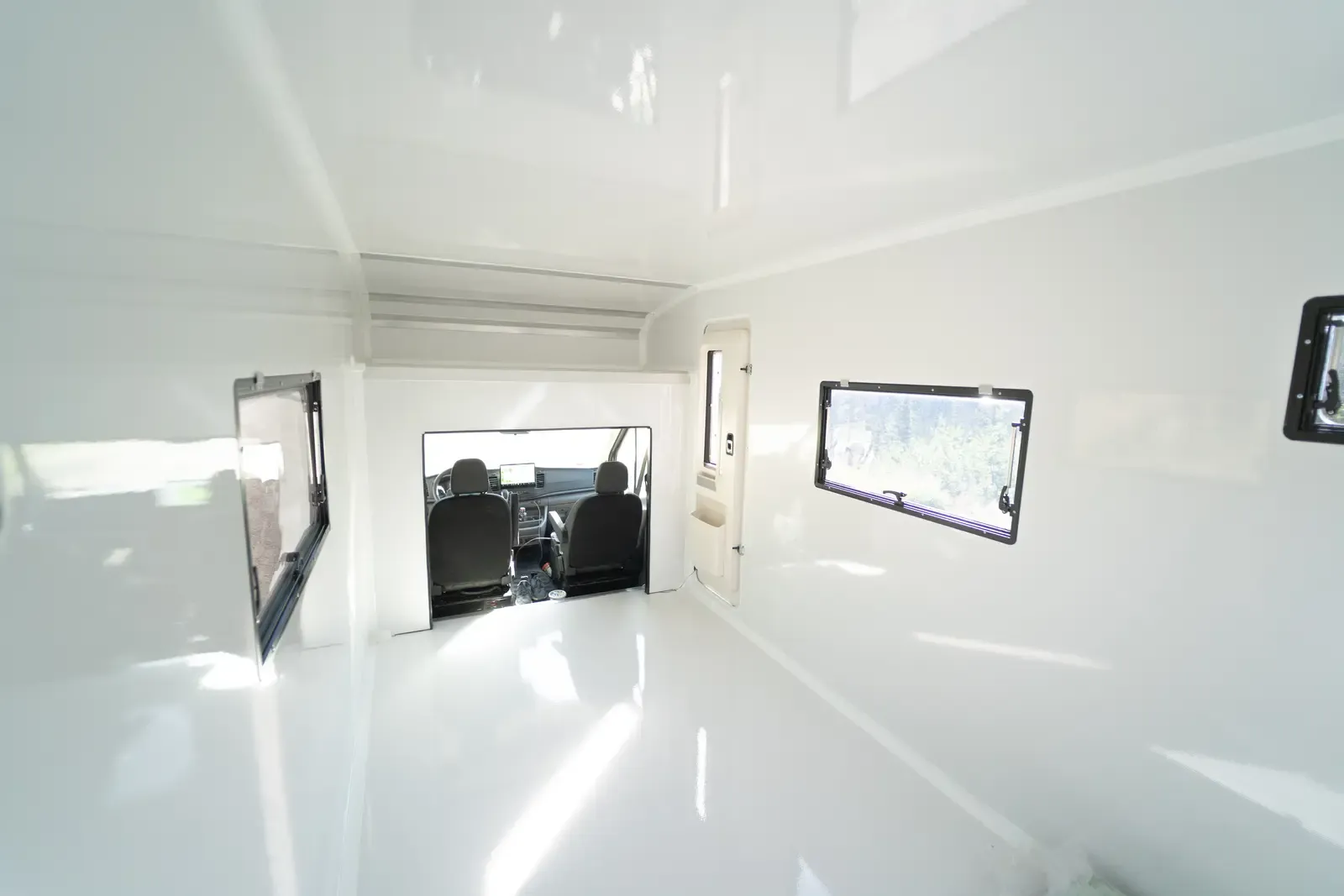 Inside the Transit's composite body with an awning window open and the cab pass-through ahead