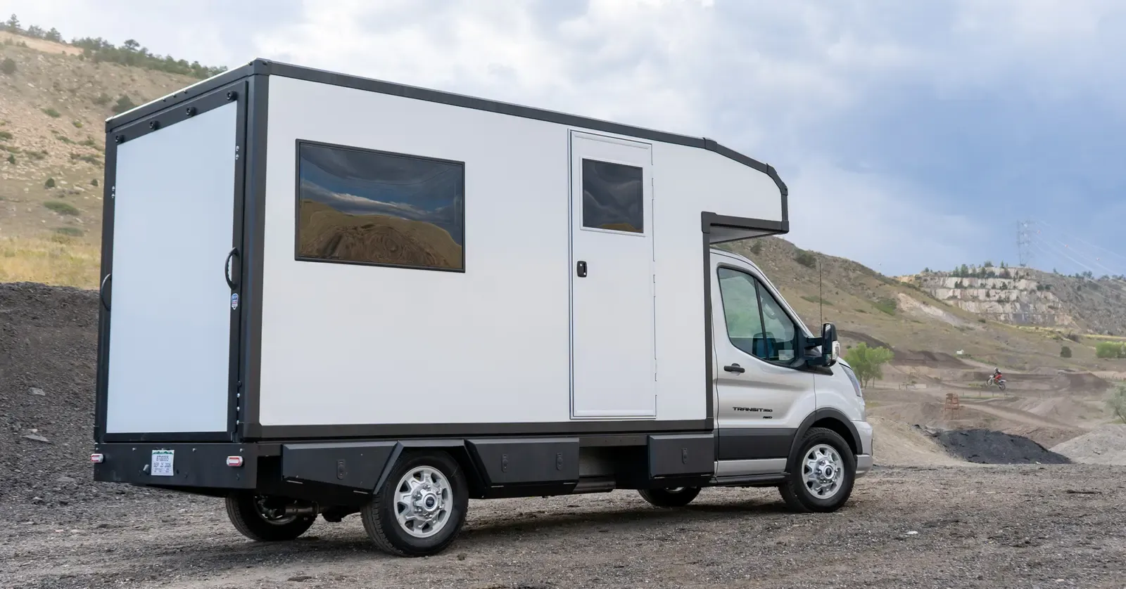 Rear three-quarter view of a Foundation Vehicles RampDeck body on a Ford Transit 156 with the rear wall closed and flush